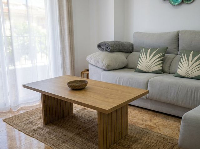 Salón con sofá, mesa de centro y cortinas