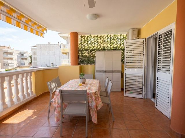 Terraza amueblada con mesa y toldo