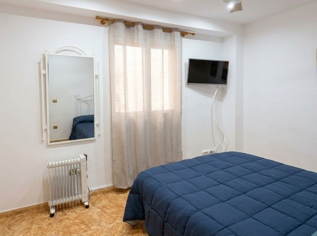 Dormitorio con ventana y radiador portátil