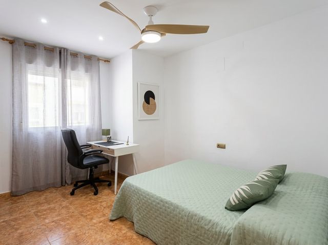 Dormitorio con ventilador de techo y zona de escritorio