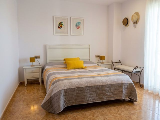 Dormitorio con cama y mesitas de noche